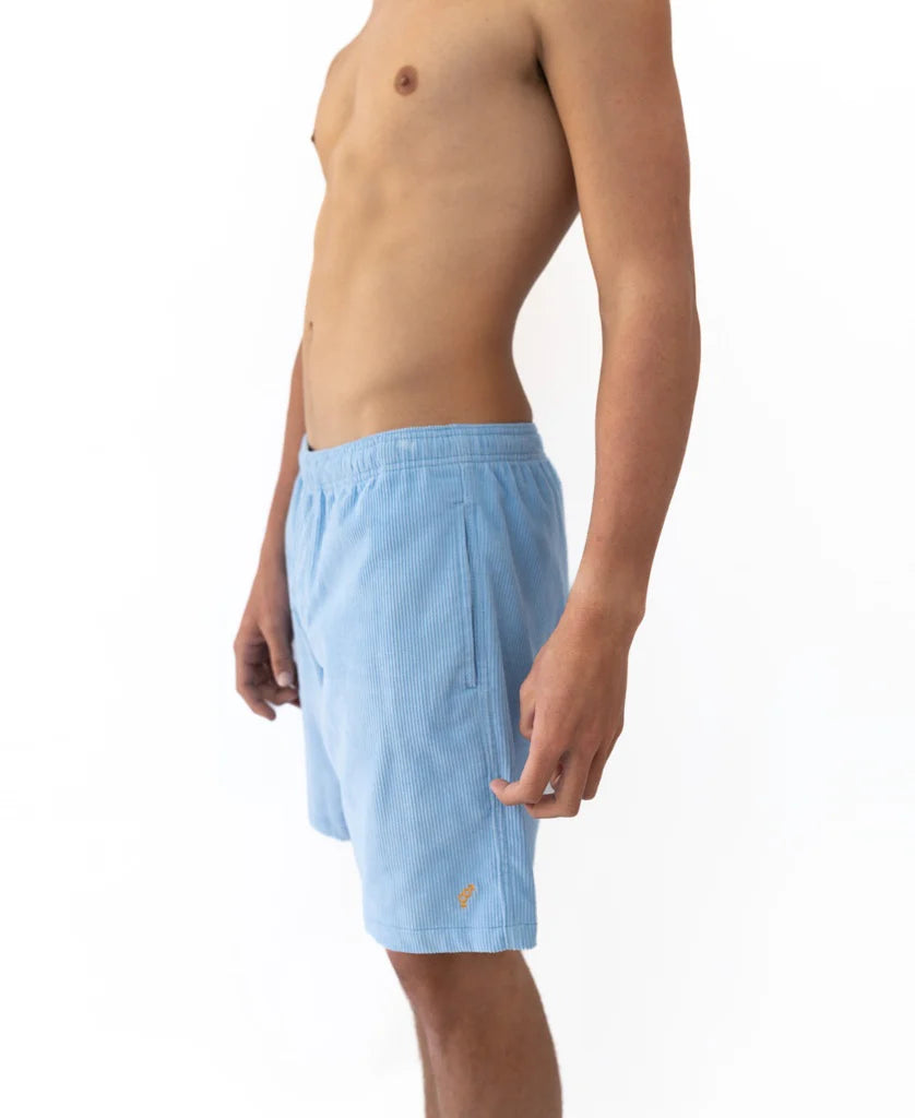 Side view of a shirtless male model wearing Floyd Cord Elastic Waist Walkshort | Blue Finch, featuring a light blue corduroy fabric and elastic waistband, suitable for casual surfwear.
