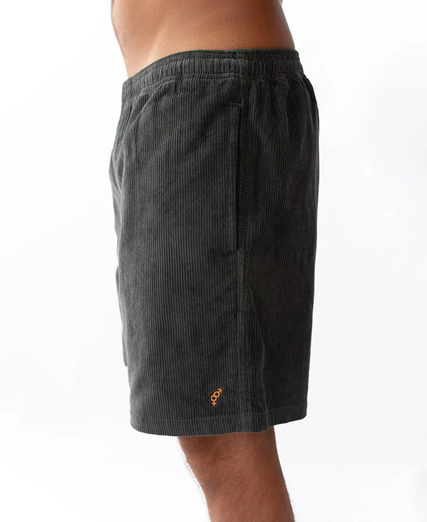 Side view of a person wearing Floyd Cord Elastic Waist Walkshort | Wash Black made from textured corduroy fabric with an elastic waistband, styled for casual surfwear.