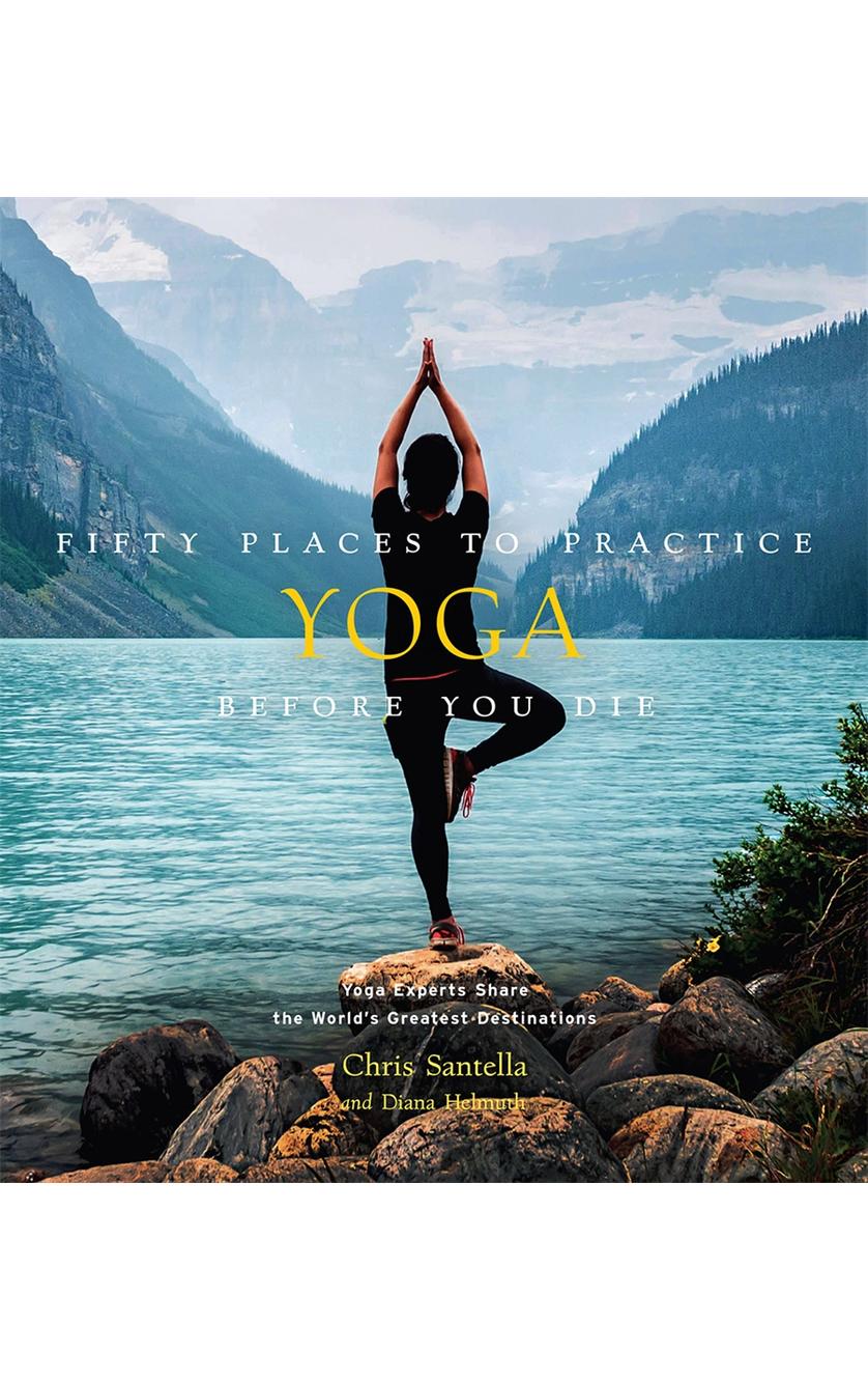 A person practices yoga in a tree pose by a mountain lake—a striking scene from the cover of Brumby Sunstates book, 50 Places To Practice Yoga Before You Die.