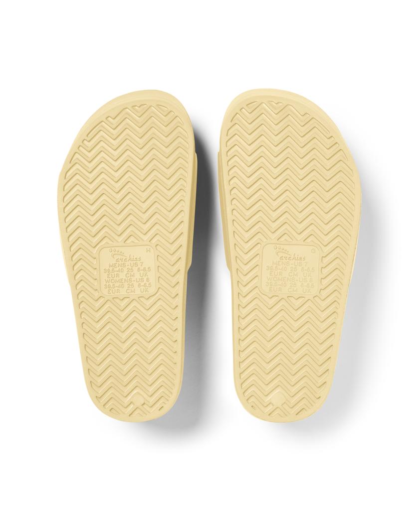 Archies Archie Slide | Lemon features beige foam soles with a textured zigzag pattern and embossed rectangular markings, designed to mold to your foot for superior comfort.