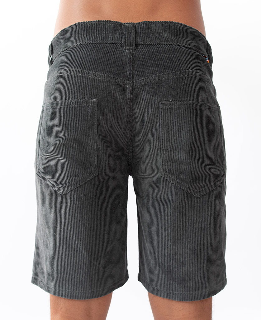 Someone wearing Golden Breeds Floyd Cord Walkshort in Wash Black—crafted from 100% cotton corduroy—shown from the back, featuring visible pockets and a structured waist for added style.