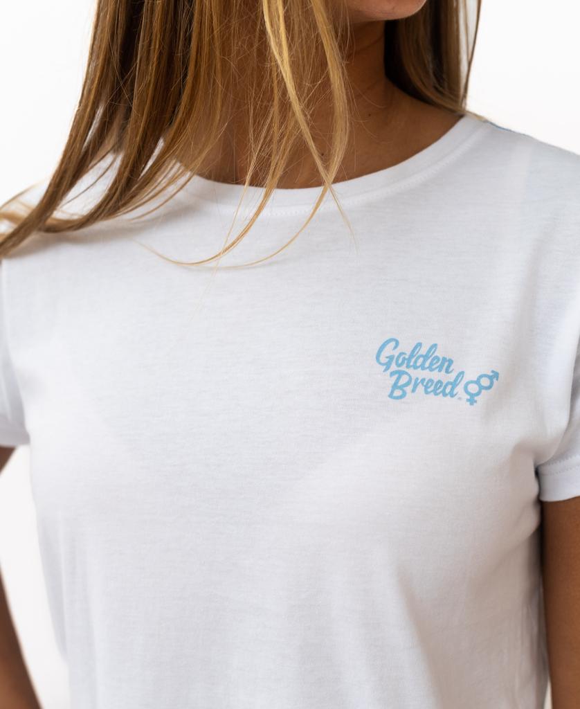 A person wearing the Golden Breed Hattie Crop Tee in white, a soft cotton cropped tee with Golden Breed and a small logo printed in light blue on the left chest.