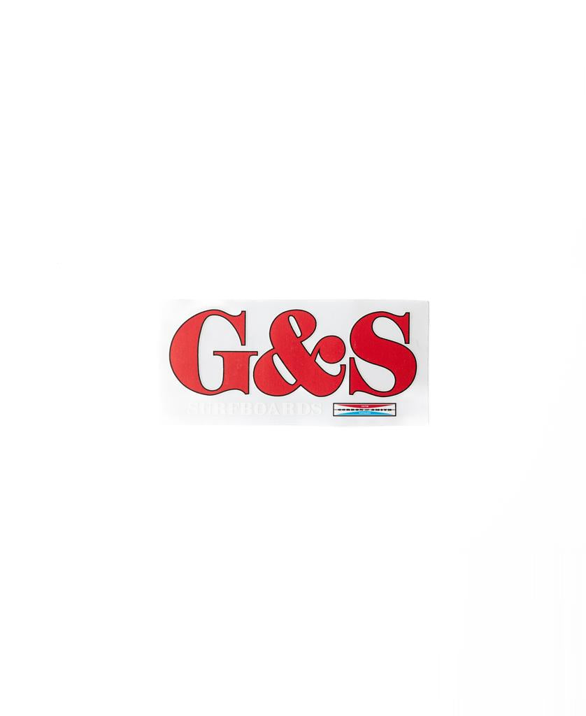 The G&S Smith Clear Sticker 130mm by Gordon & Smith features large red G&S letters above SURFBOARDS on a clear background, showcasing the iconic brand logo in a sleek rectangular design.