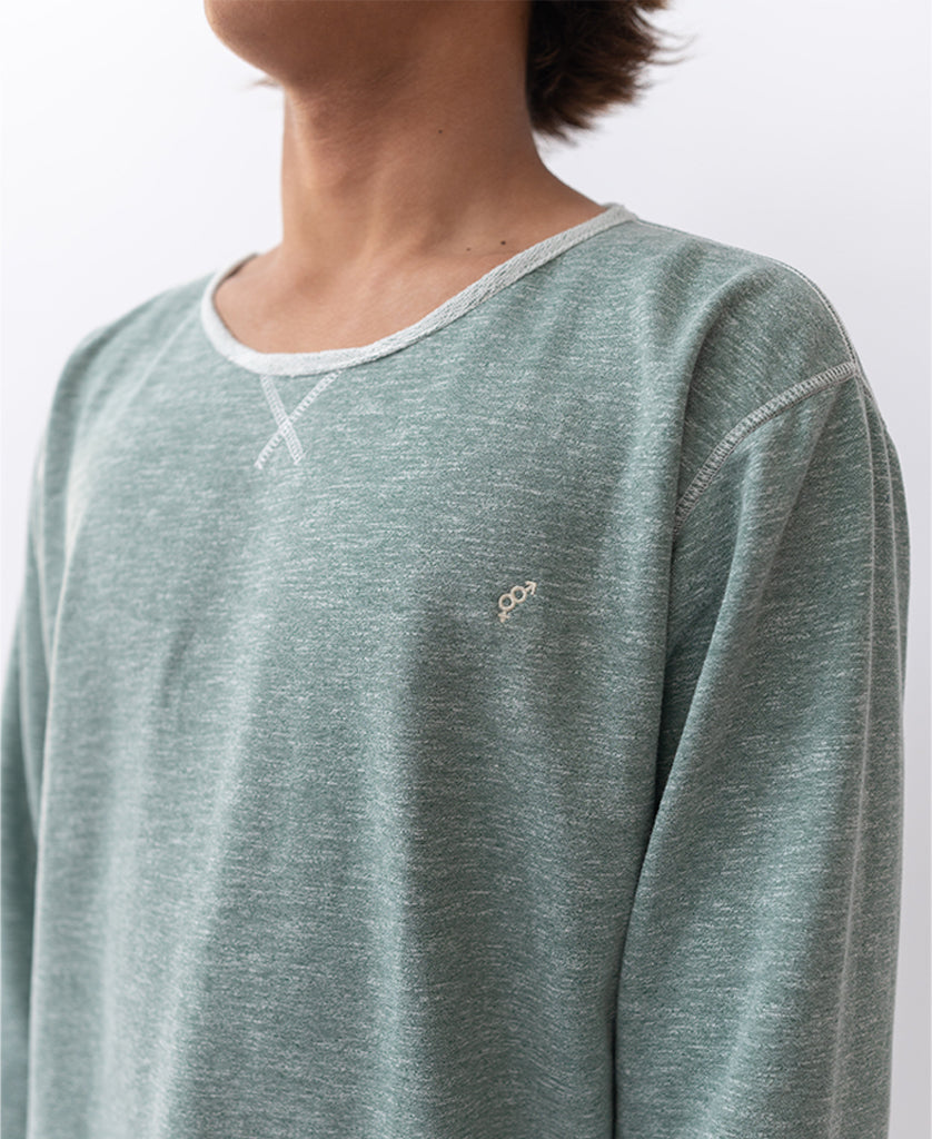 Person wearing a Golden Breed Classic Rag Top in Surf Green Marle, featuring white stitching, a small chest logo, and an oversized relaxed fit, shown from the shoulders up against a plain background.