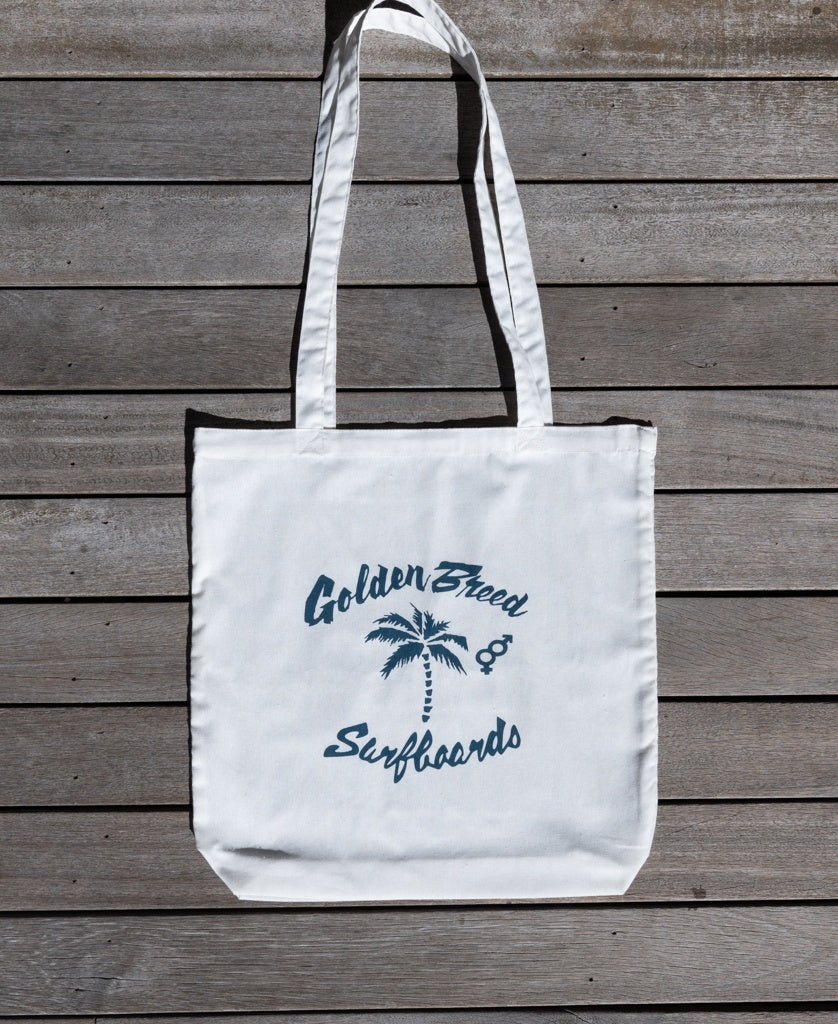 The Bardot Logo Tote Bag in Off White by Golden Breed features a blue palm tree and surfboards graphic—a stylish, eco-friendly cotton tote ideal for daily essentials.