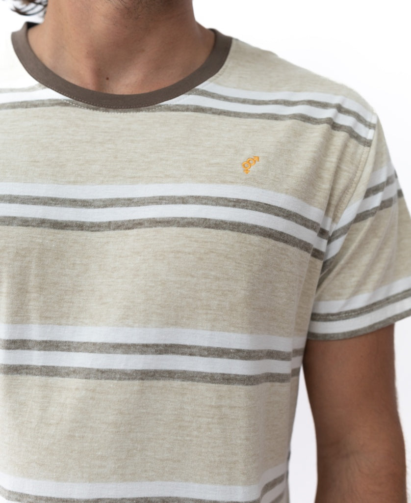 A person wearing the Golden Breed Bay Stripe Tee in Mocha: a beige and white striped cotton short-sleeve shirt with a brown collar and small yellow chest logo—classic Golden Breed style.