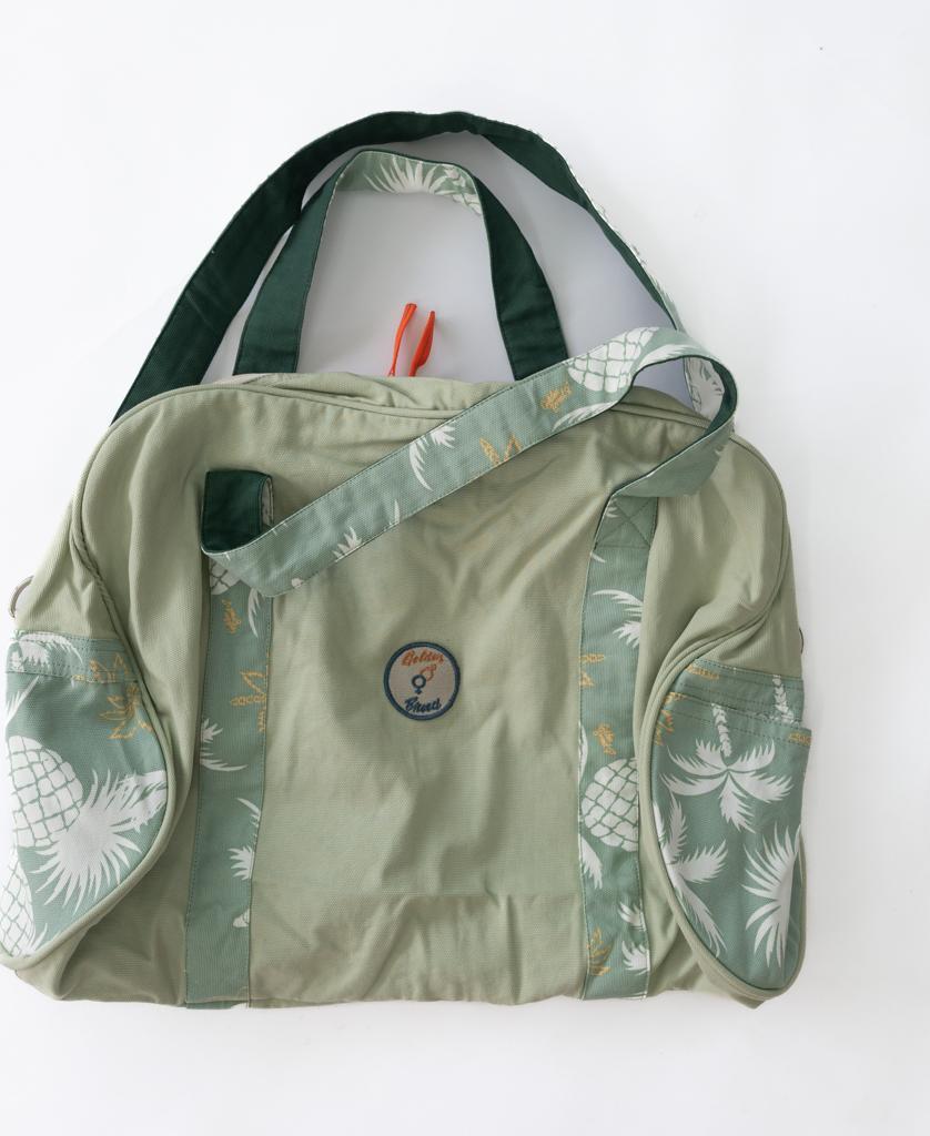 Golden Breed Pine Palm Canvas Roll Bag in Sage features palm and pineapple prints, two handles, adjustable strap, and a “Cheery Resort” patch. Designed in Australia for style and durability.