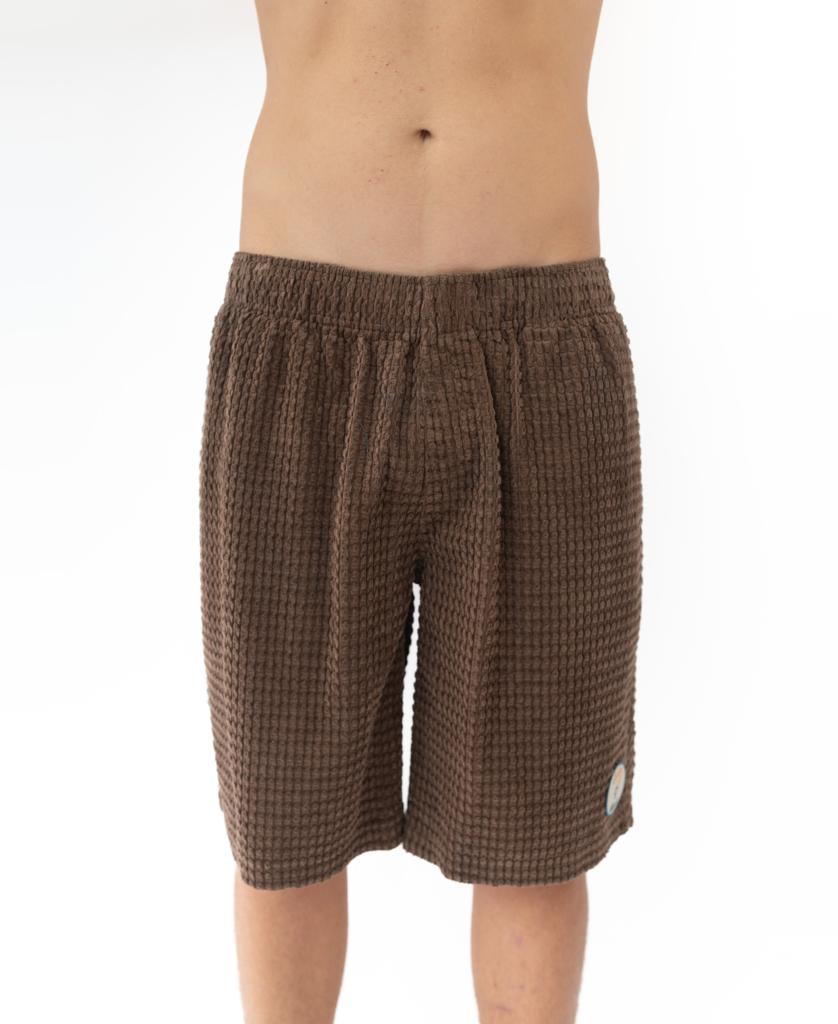 A person wearing Golden Breed El Solito Walkshort in Wash Brown, seen from waist to knees, stands against a plain white background.