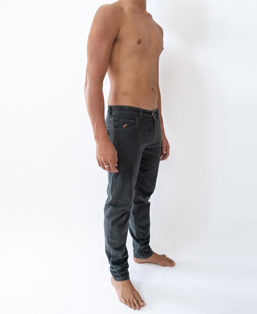 A barefoot, shirtless person stands against a white background, wearing Golden Breed Felix Stretch Cord Pant in Wash Black.