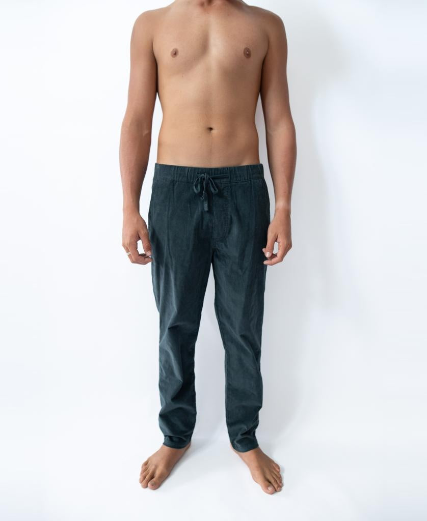 A barefoot person stands against a white background, wearing the Golden Breed Fred Stretch Cord Pant in blue, featuring an elastic waist with drawstring and no shirt.