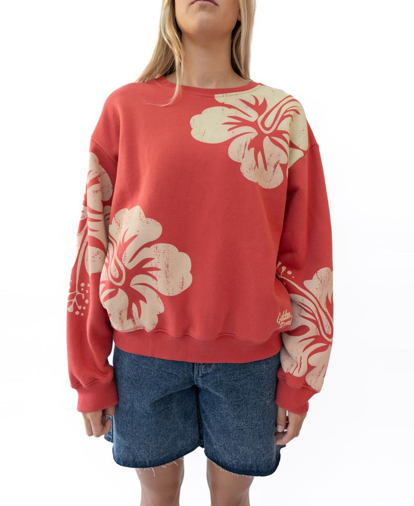 Wearing the Golden Breed Hibiscus Sweat | Wash Red/Beige, featuring bold beige floral prints on red 100% cotton fleece, paired with blue denim shorts and set against a white background.