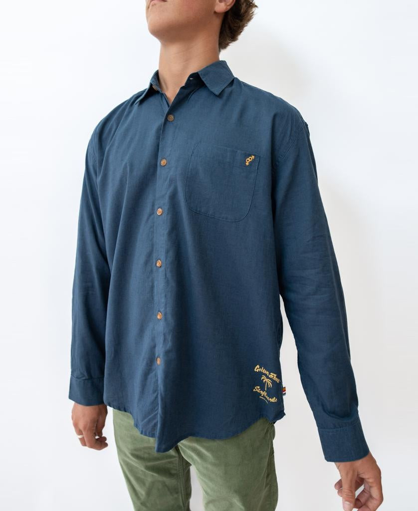 A person wearing the Golden Breed Linen LS Shirt in Vintage Navy stands against a plain white background, paired with green pants.