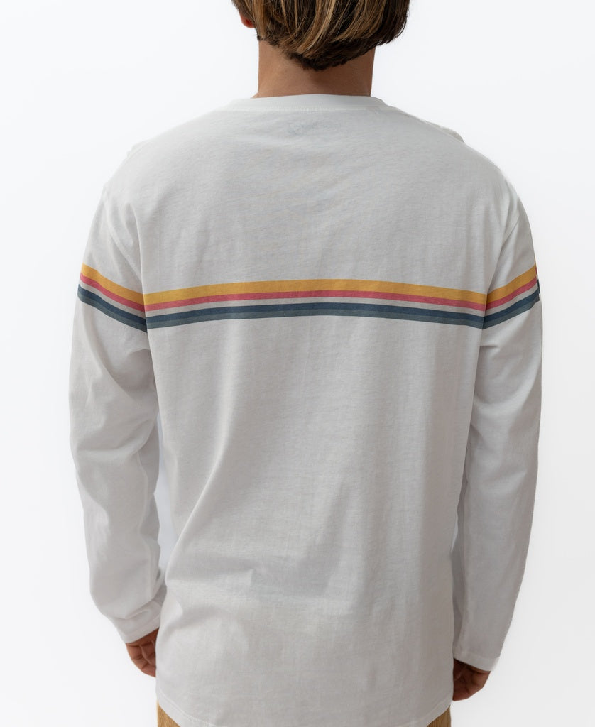 A person wears the Golden Breed Manly Cali Long Sleeve Tee in off white, featuring retro red, orange, yellow, and blue stripes across the upper back, standing against a plain background.