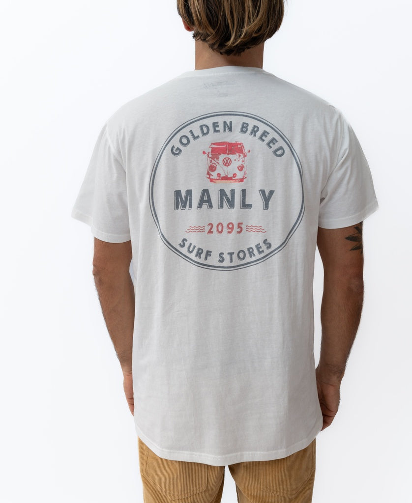 A man faces away, wearing the Golden Breed Manly Kombi Tee in off white, featuring a red Kombi graphic and Surf Stores print on the back.