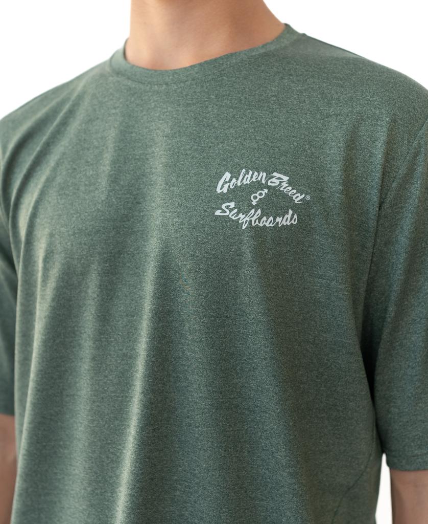 A person wearing a Green Marle Nemo S/S Rash Shirt by Golden Breed, featuring white “Golden Breed” text on the left chest.