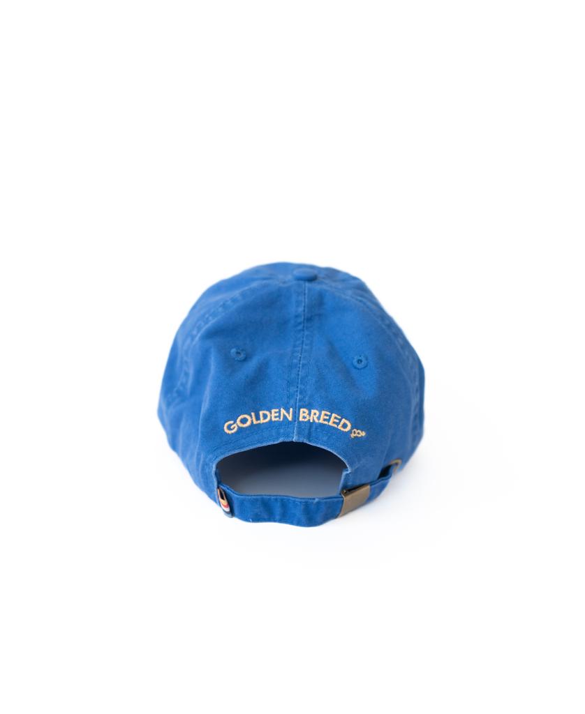 The Golden Breed Palm Cap | Pacific is a blue cap featuring GOLDEN BREED embroidered in white above the adjustable strap—ideal for beach vibes.
