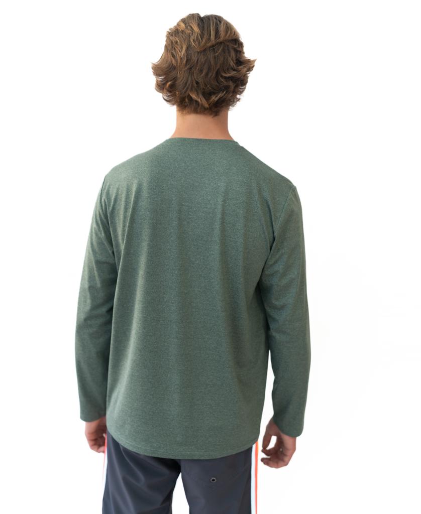 A person with light brown hair, seen from behind, wears the Golden Breed Pebbles L/S Rash Shirt in Green Marle (50+ UPF) and dark pants with white and orange side stripes, set against a white background.