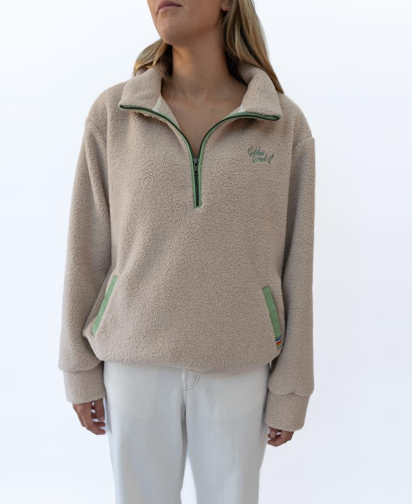 A person wearing the Golden Breed Sammie 1/2 Zip in beige with green zipper accents and white pants, standing against a plain white background.