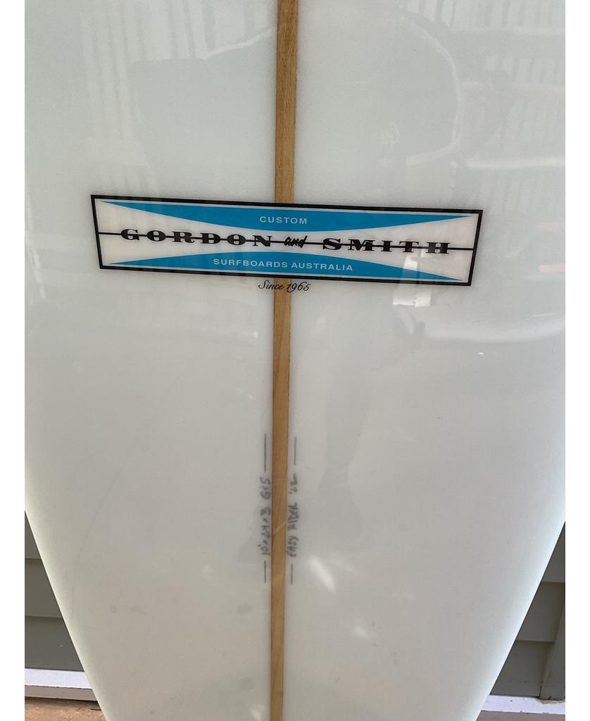 Close-up of a Gordon & Smith G&S 10 Easy Rider Polish Finish | White surfboard label reading Custom Gordon and Smith Surfboards Australia Since 1963 on a white longboard with visible wood stringer.