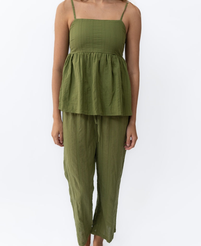 Model wears the Lazy Beach Celine | Khaki Stripe set—an olive green sleeveless peplum top with matching loose-fit pants—standing against a plain white background.
