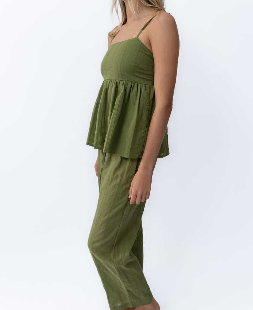 A woman models the Lazy Beach Celine | Khaki Stripe set—a sleeveless peplum top and matching wide-leg pants—standing sideways against a plain white background.