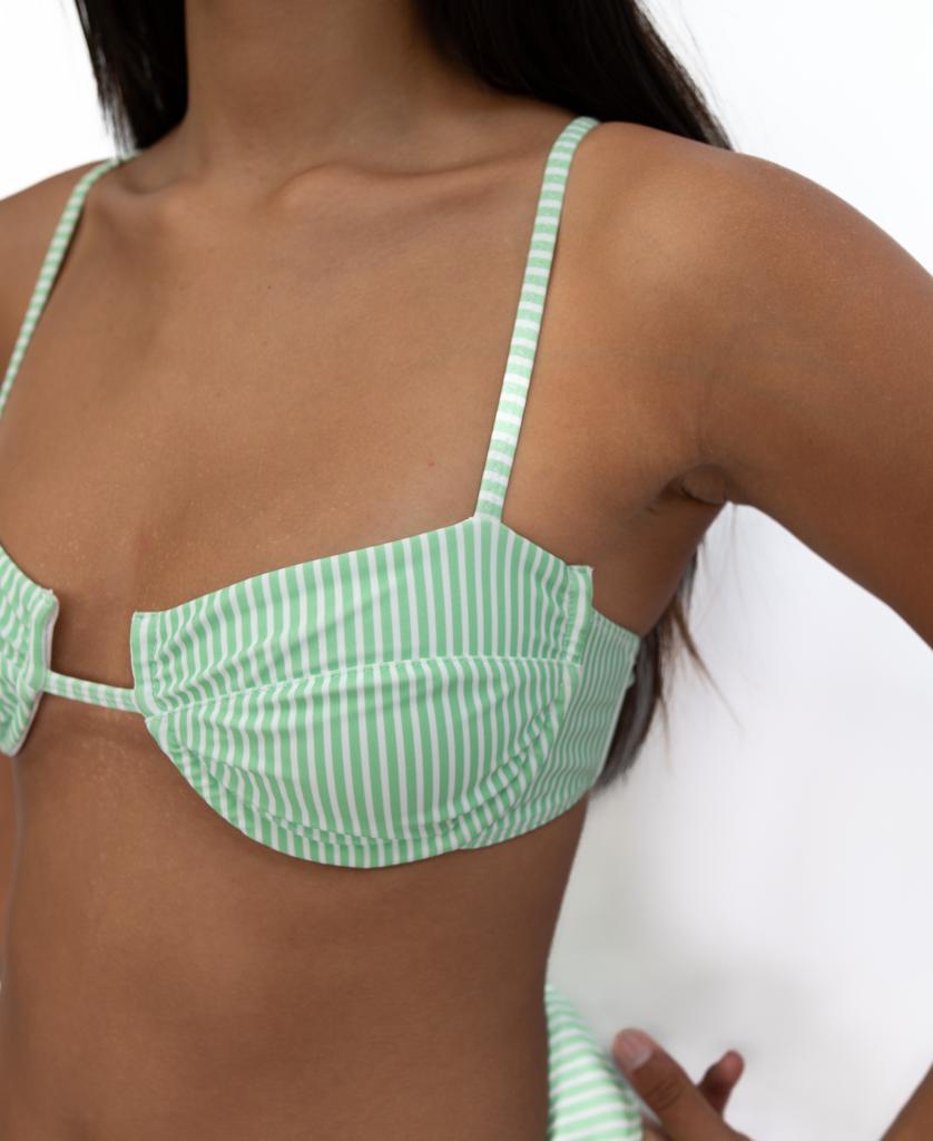 A person models the Lazy Beach Mischa Bikini Top in green and white stripes, standing with one hand on their hip against a plain background.