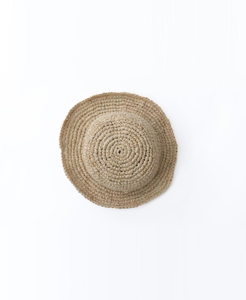 The Lazy Beach Raffia Bucket Hat | Natural, featuring a wide brim, is handmade and shown from above on a plain white background—ideal for summer style.
