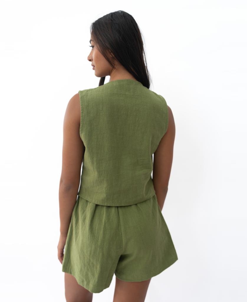 A person with long dark hair wears the Lazy Beach Rennie Vest in khaki, standing against a plain white background, facing away from the camera.
