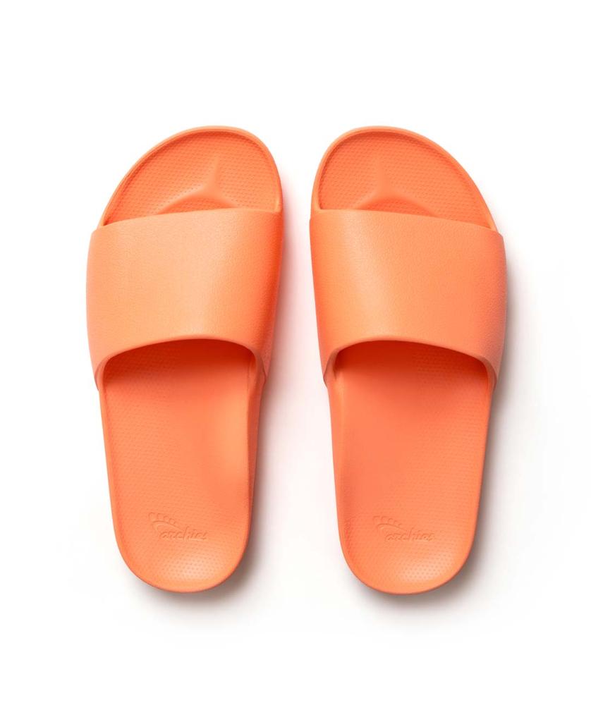 A pair of Archies Archie Slide | Peach arch support slides, featuring a wide strap and textured footbed made from closed cell foam, are shown side by side on a white background.