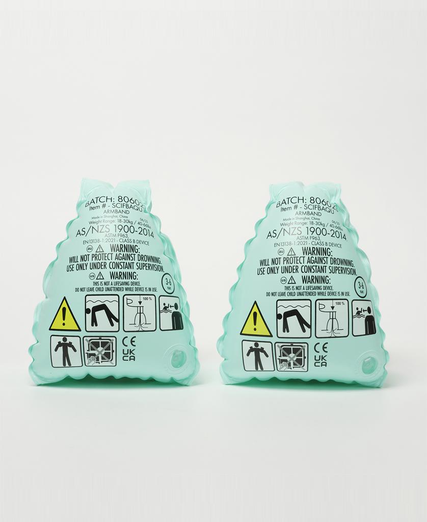 The Sunny Life Salty the Shark Float Bands in aqua are shown upright against a white background, featuring safety icons and Salty the Shark—ideal for helping kids build swimming skills.