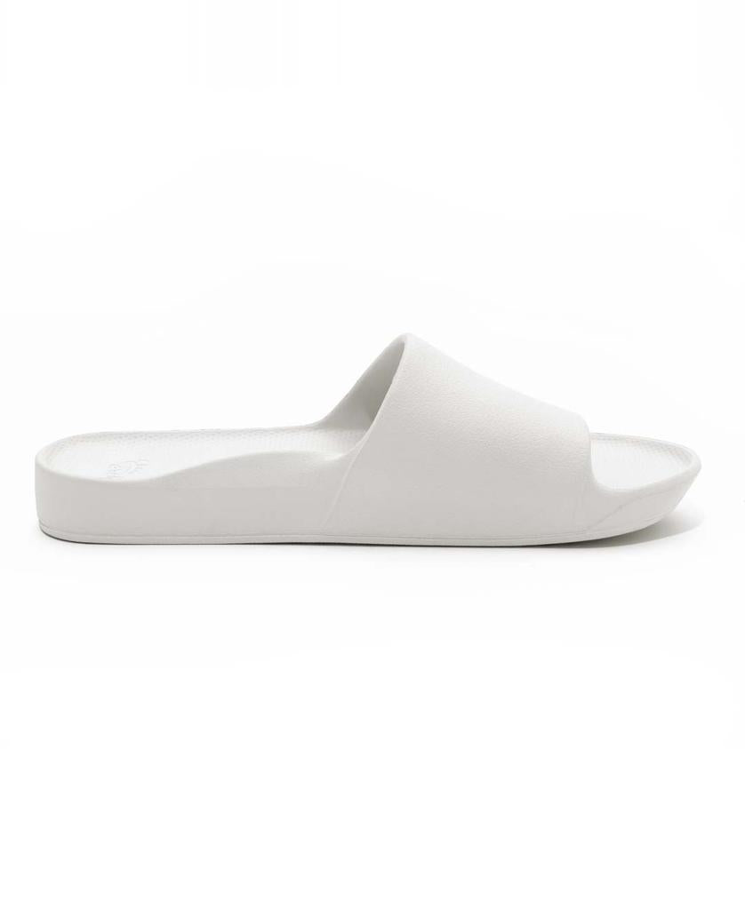 The Archies Archie Slide in White features a wide strap, flat sole, and open-toe design for all-day comfort and support. Displayed in side profile on a white background.