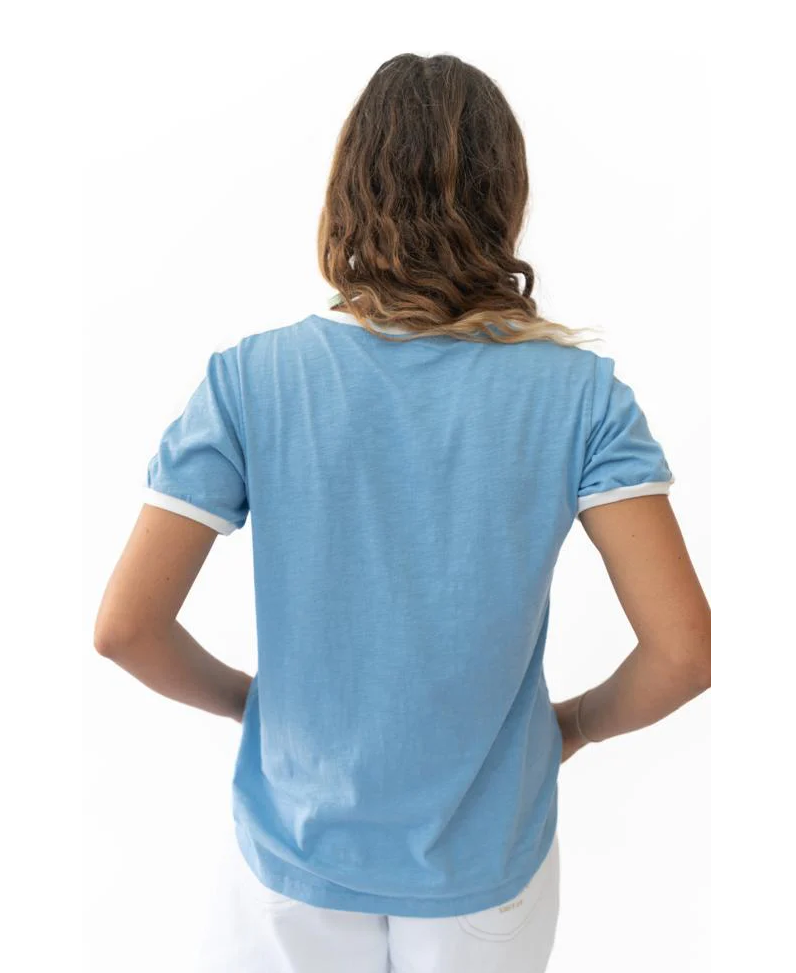 Person wearing a casual light blue Retro Ringer Tee | Azure with white trim, shown from the back in a bright setting, embodying laid-back surfwear style.