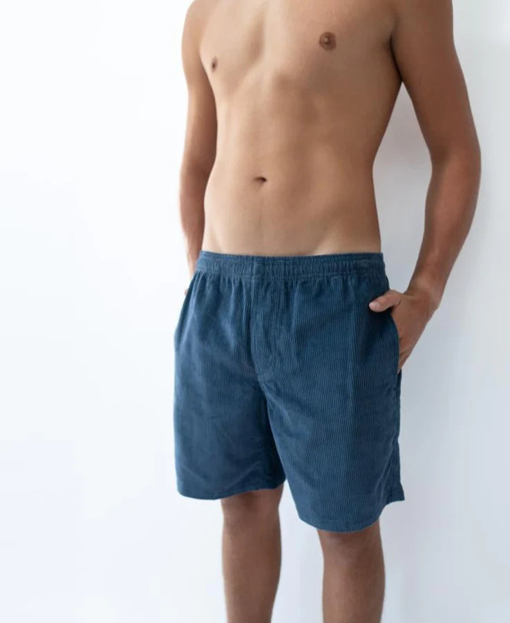Man wearing Floyd Cord Elastic Waist Walkshort | Vintage Navy with hands in pockets, styled with a relaxed fit and textured corduroy fabric, perfect for casual Australia surfwear.