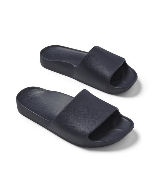 The Archies Archie Slide in navy features thick closed cell foam soles and wide straps that mould to your foot, shown on a white background.