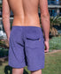 A person stands outdoors, seen from behind, wearing Golden Breeds Floyd Cord Elastic Walkshort in Port—purple cotton corduroy shorts featuring an elastic waist and flap pocket. Their upper body is bare.
