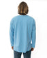 A person with shoulder-length hair faces away, wearing the Golden Breed Classic Rag Top in Sky Marle and dark pants, embracing a subtle retro vibe against a plain white background.