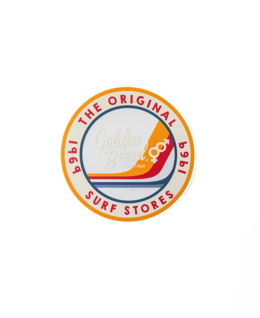 The Golden Breed GB Duke Sticker 110mm | Clear is a high-quality round sticker with Golden Breed since 1969 in the center and The Original Surf Stores 1969 around the edge, featuring vibrant red and orange accents.