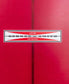 A close-up of the G&S Log Cardinal 98 red longboard surfboard by Gordon & Smith, featuring the brand’s logo label at the center.