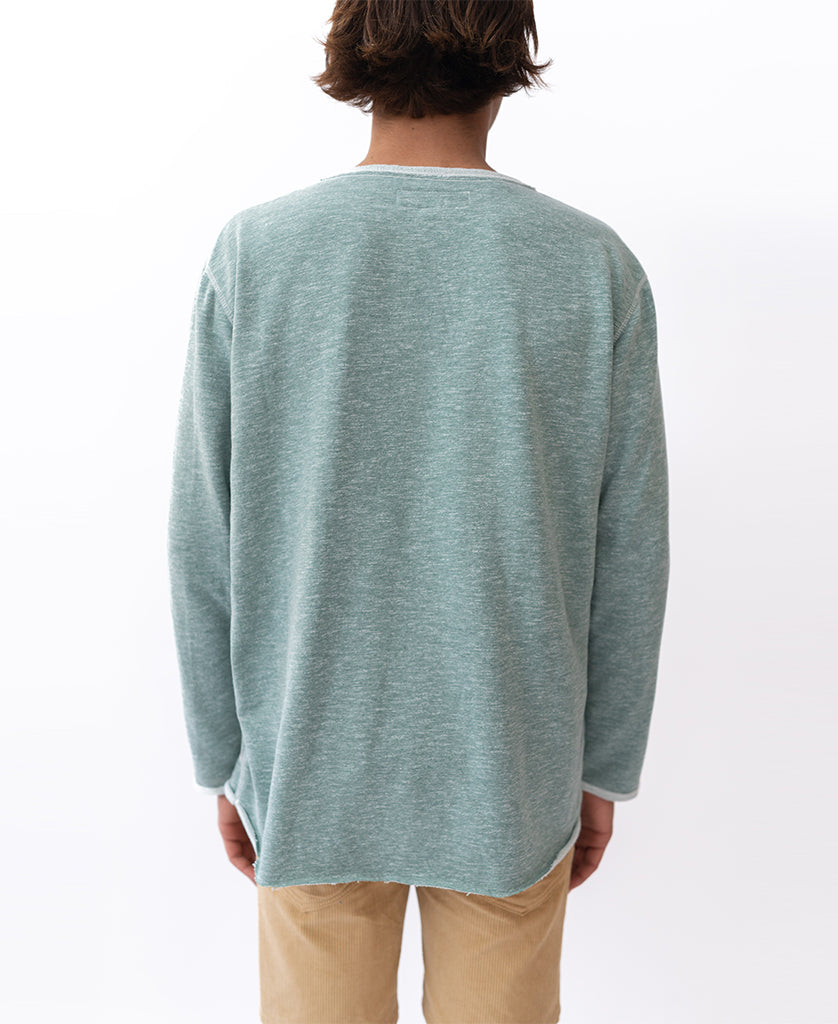 A person faces away from the camera against a white background, wearing beige pants and the Golden Breed Classic Rag Top in Surf Green Marle.