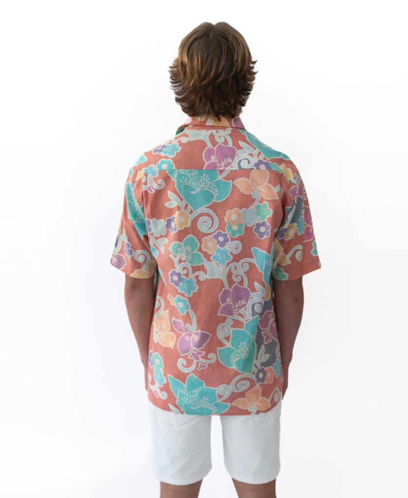 A person with medium-length hair faces away, wearing a Golden Breed Batik Shirt | Rose and white shorts against a plain white background.