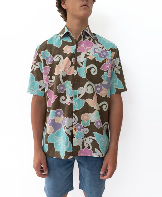 A person wearing a Golden Breed Batik Shirt | Wash Brown with blue shorts, standing against a white background.