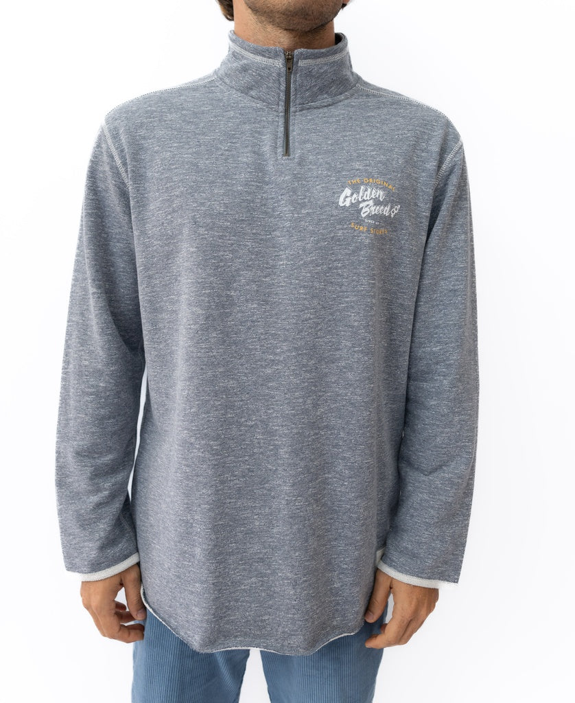A person wearing the Golden Breed Break 1/4 Zip Rag Top in Navy Marle, featuring text and small graphics on the left chest, shown from the waist up against a white background.
