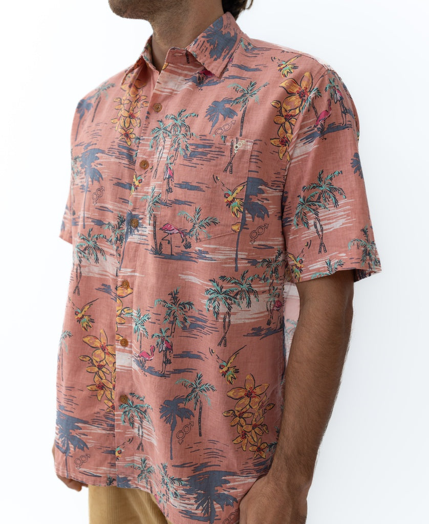 Man in Golden Breed’s Flamingos Shirt | Rose—a short-sleeve, button-up with pink and blue tropical print, palm trees, and flowers. Crafted from a breathable cotton/linen blend for comfort.