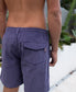 A person wearing Golden Breed Floyd Cord Elastic Walkshort in Port stands outdoors near green plants and a white wall.
