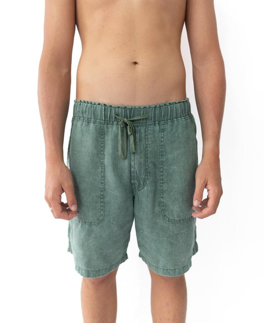 A person models the Golden Breed Linen Short in Khaki, featuring an elastic waist, standing against a plain white background and displaying the shorts from waist to just above the knees.