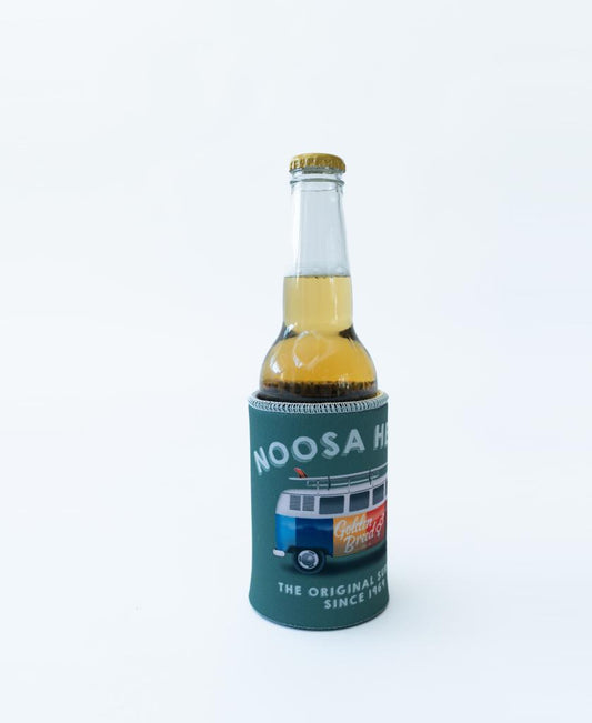 A bottle of beer in the Golden Breed Noosa Stubby Kombi | Surf Green holder featuring “NOOSA HEADS” text, a van illustration, and additional text below, all on a plain white background.