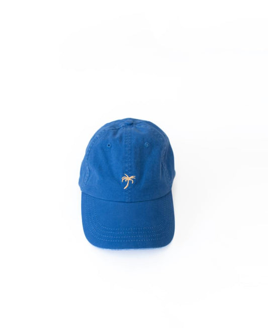 The Golden Breed Palm Cap | Pacific features a small yellow palm tree embroidered on blue fabric, adding subtle beach vibes. Shown against a plain white background.