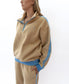 A woman models the Golden Breed Peggy 1/2 Zip Retro tracksuit in Beige/Azure, featuring blue trim and a vintage sweat collar, standing against a white background.