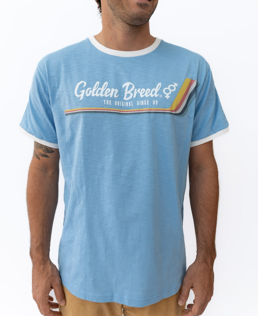 A man wears the Golden Breed Retro Ringer Tee in Azure Blue, featuring The Original Since 69 and a multicolor stripe graphic on the chest, inspired by 70’s style. Made from 100% cotton for comfort.