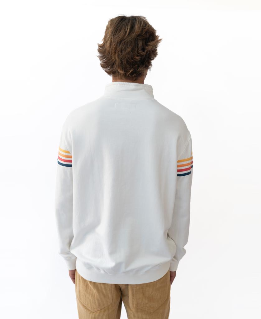 A person with medium brown hair faces away, wearing the Golden Breed Long Island Fleecy Top in Off White, featuring colorful striped sleeves and tan pants, against a plain white background.